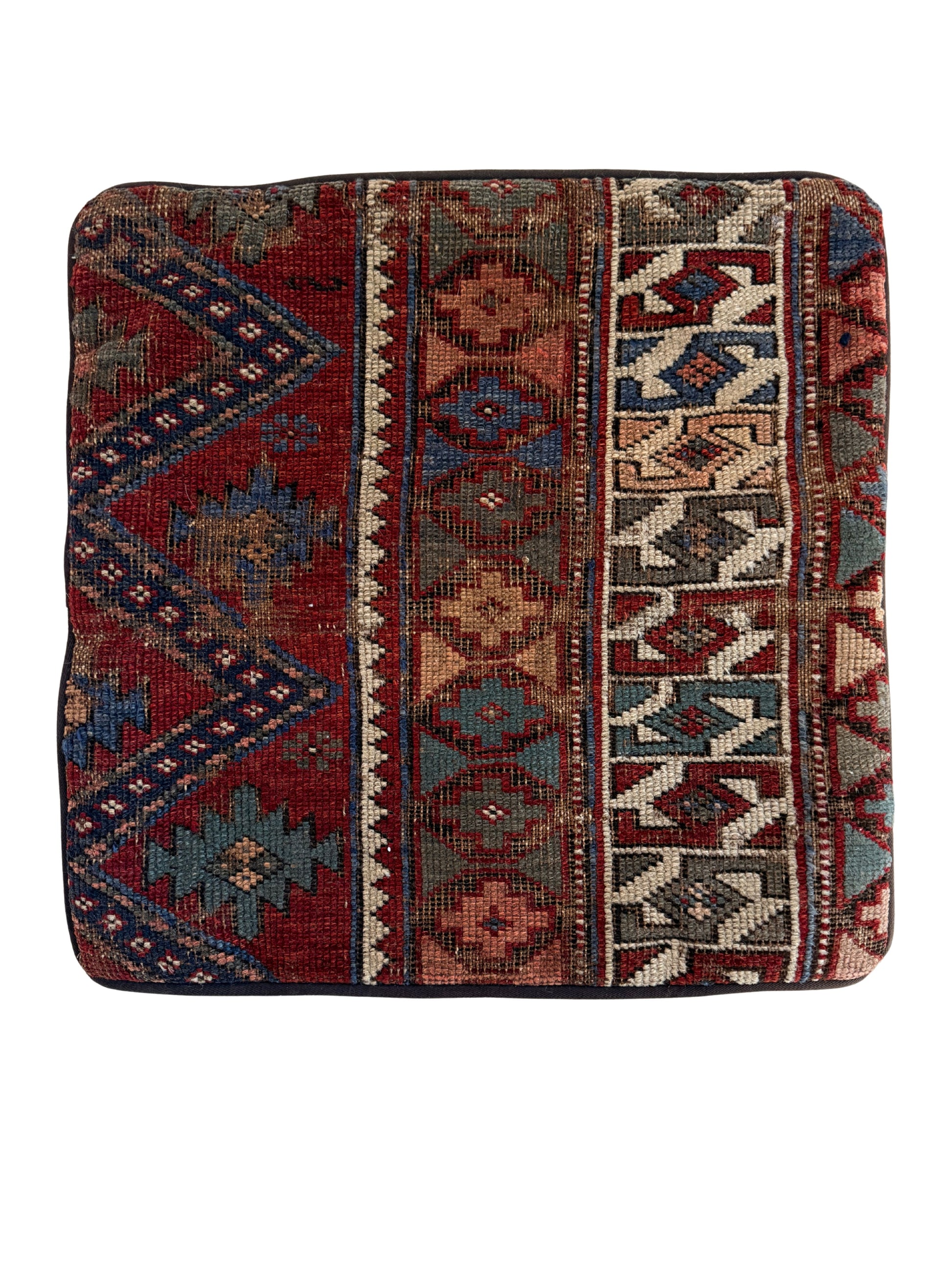 Caucasian vintage rug pillow in ruby red with blue, teal and cream accents in a geometric pattern.