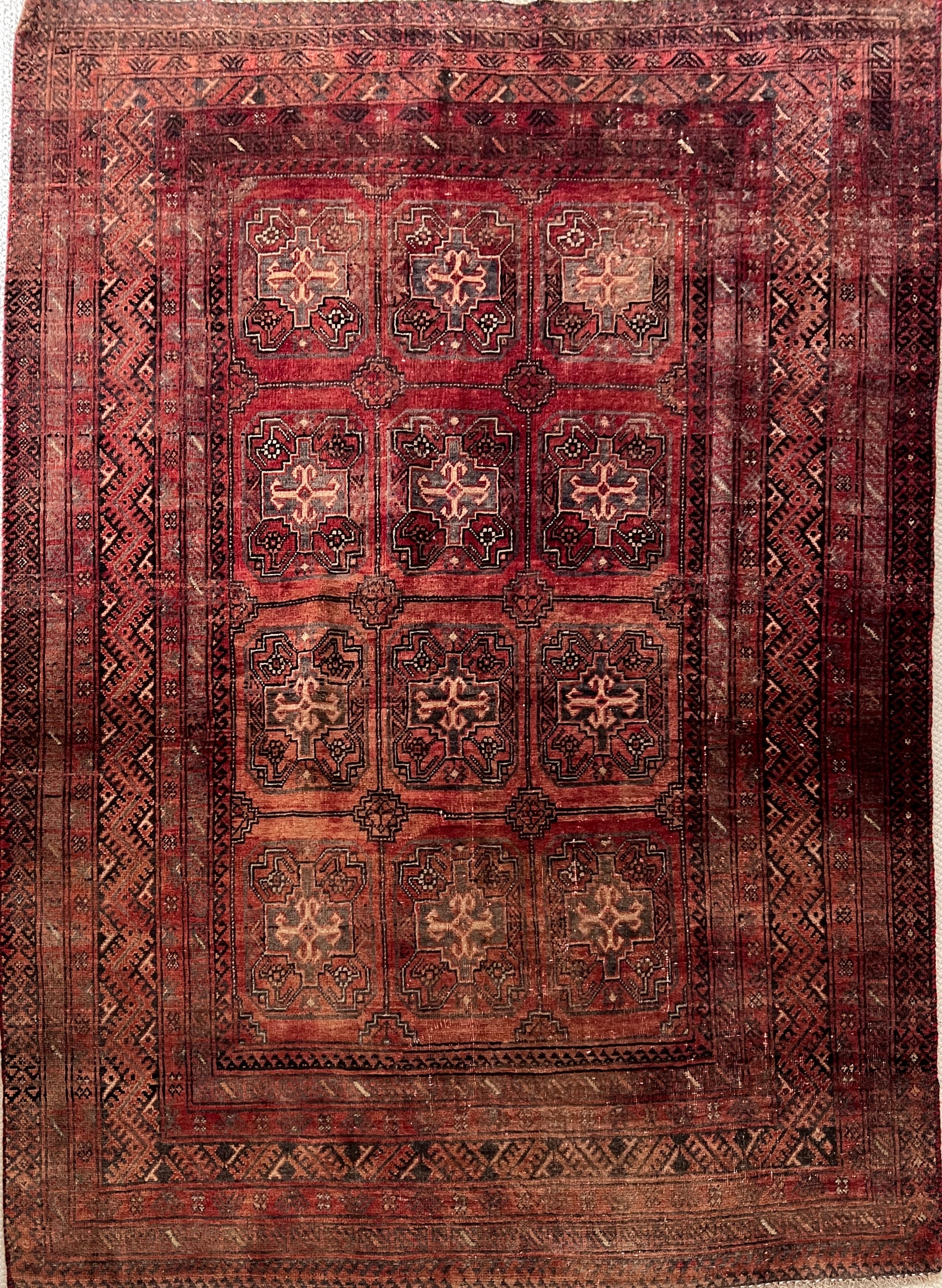 Vintage Persian Turkoman wool area rug, 4x6, full image with varying shades of red and rust in a geometric pattern with cream, charcoal and dark brown accents.