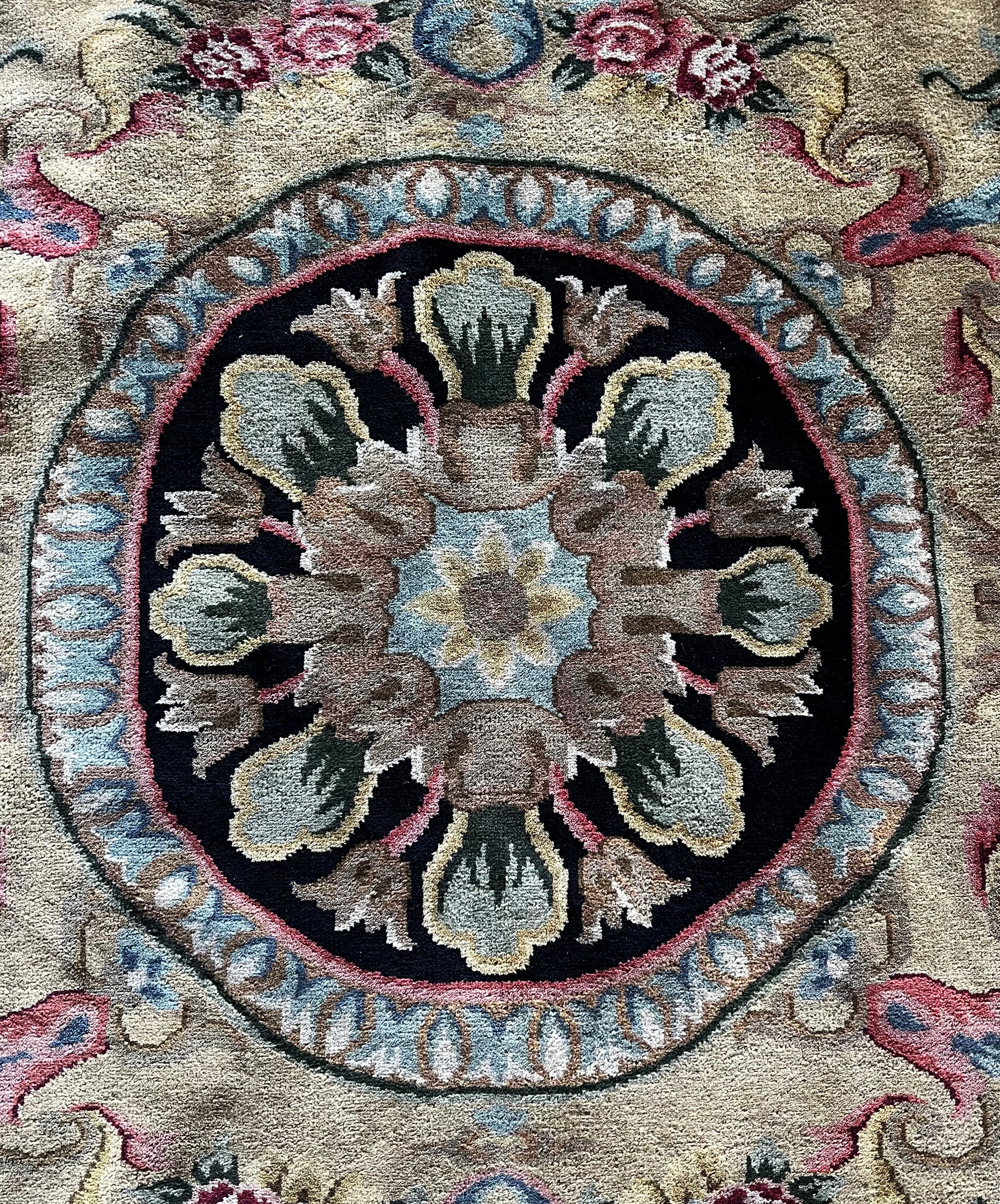Vintage Indo-Aubusson large wool rug, hand-knotted in India, features a large center medallion with pale blue, black, pale pink and rose shades, and buttery gold.
